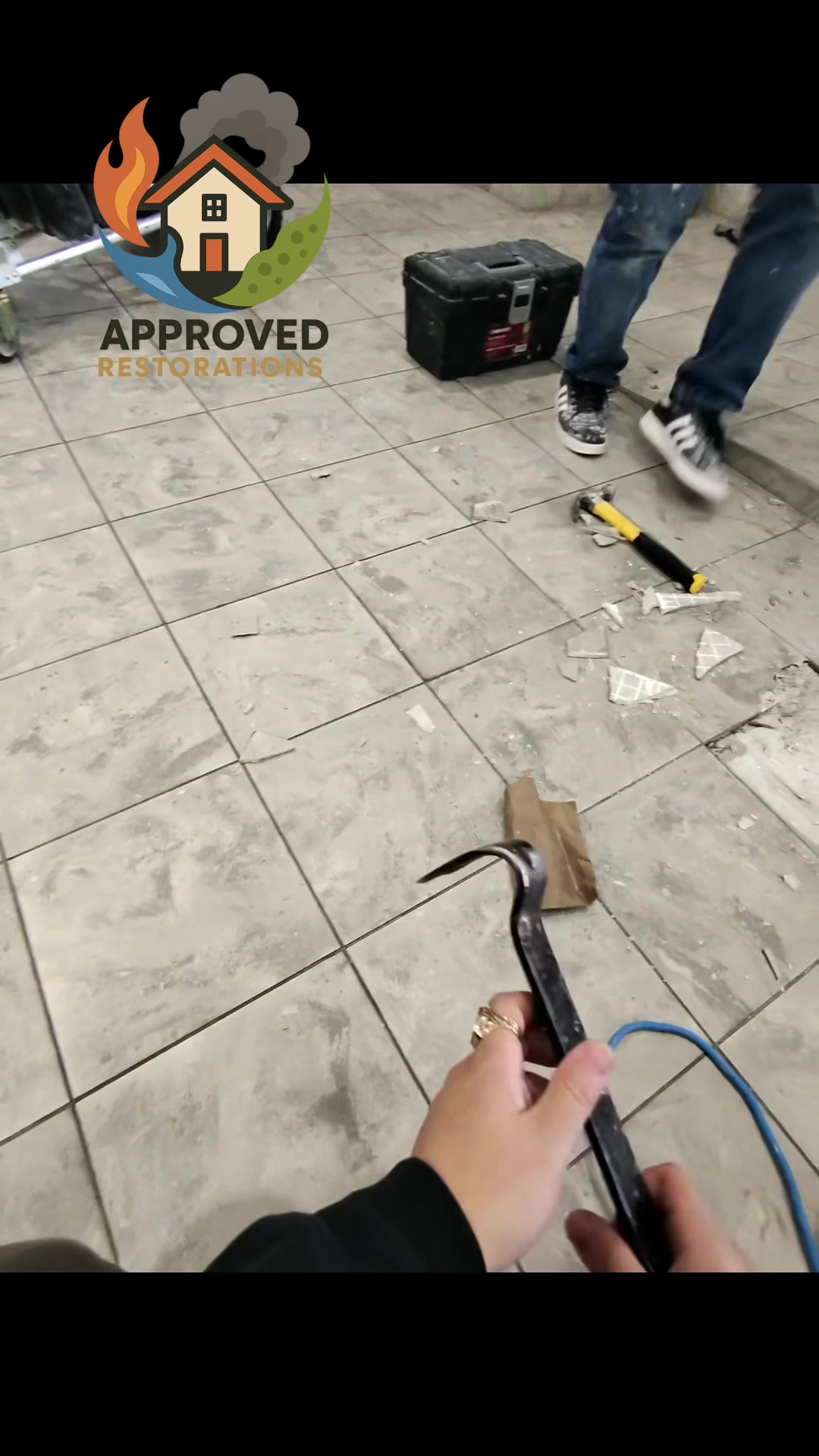 Because the original installers failed to back-butter these condo floor tiles, leaving hollow pockets that easily crack under normal foot traffic or water damage, our crew is tearing out the entire botched floor—pulling up loose tiles that pop off completely clean—to prep the concrete and rebuild it right.
