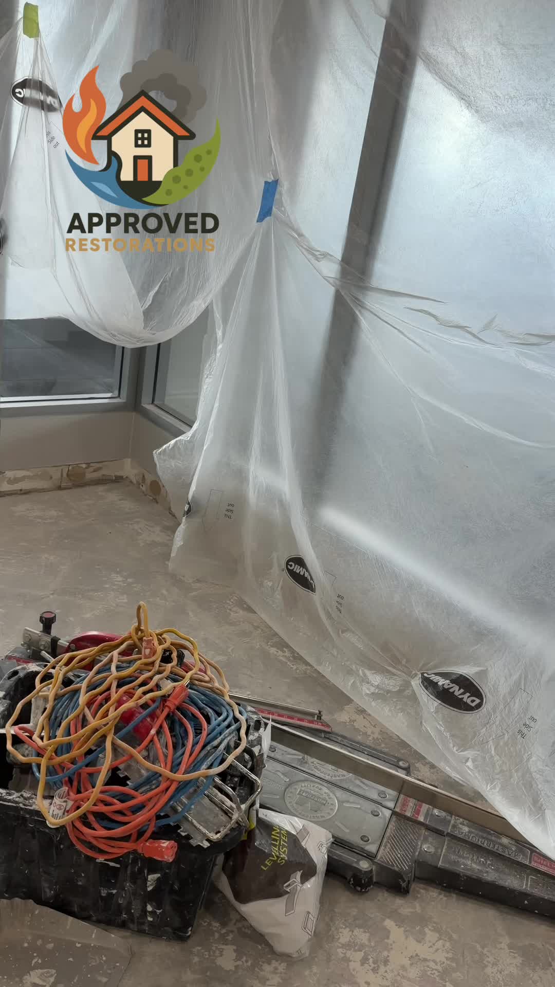 We're making major progress on this condo water damage rebuild, having ripped out the old flooring and laid fresh, marble-look tile down the main hallway. We've got the new floors protected with builder's paper and caution tape up where the glass crew just measured for a custom railing, bringing a completely fresh look to the space before our cleaning team arrives for the final polish.