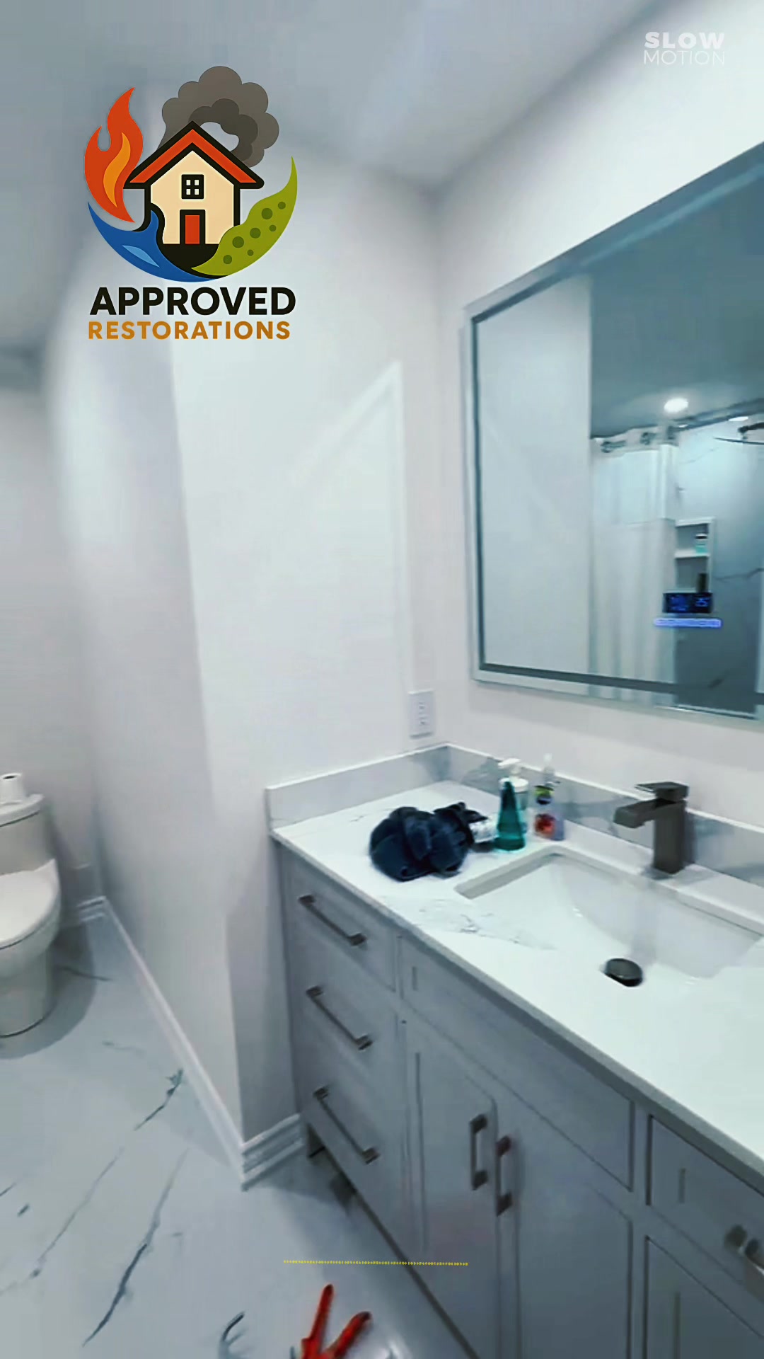 Following a major water damage claim that gutted this space, our crew is conducting a final inspection on the complete bathroom rebuild, checking the freshly laid marble-patterned floor tile and sleek modern vanity before we pack up the last tube of sealant and hand the restored room back to the homeowner.