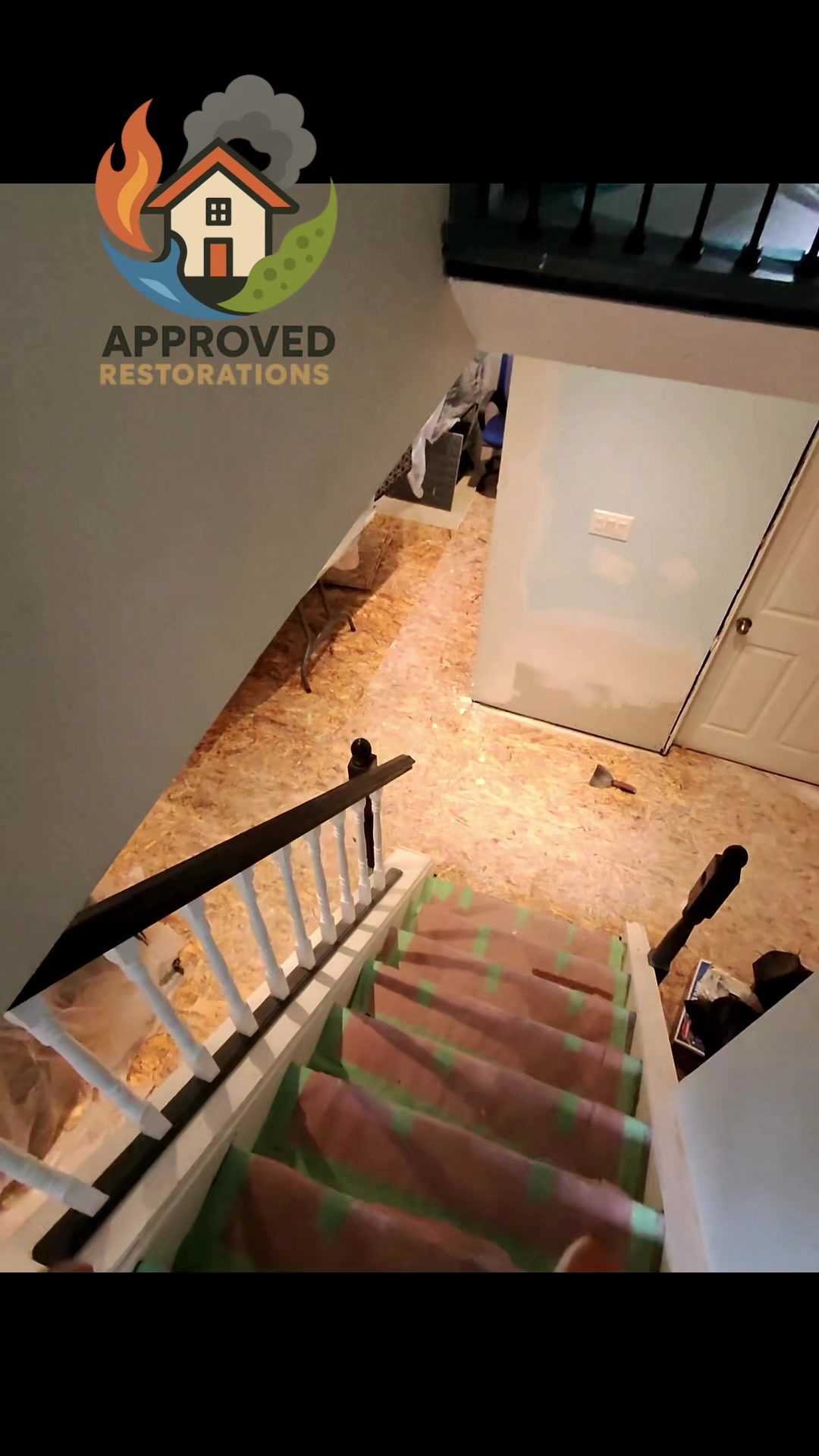 A sump pump failure left this finished basement under water, so our crew stripped the ruined flooring down to the bare OSB subfloor, taped protective runners over the stairs to shield the main house, and started mudding the fresh drywall to get the space prepped for a full reconstruction.