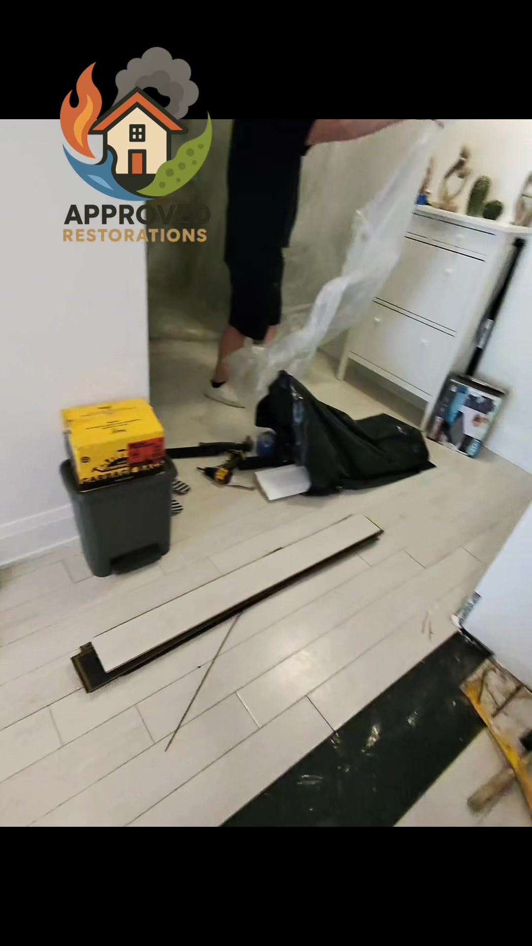 Tackling major water damage in a Toronto condo, our crew is pulling up laminate flooring that looks perfectly dry on the surface but is hiding pools of standing water underneath, so we are stripping out the saturated boards and hanging plastic containment to prep the space for a full dry-out.