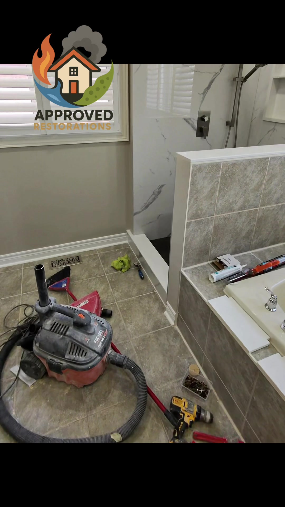 After a severe shower leak ruined this bathroom's floor and the ceiling below, our crew is wrapping up the rebuild—the new tile shower is water-tested and working flawlessly while we wait on the glass, and our techs are currently fitting trim on an upgraded vanity before dropping in a quartz countertop and LED mirror.